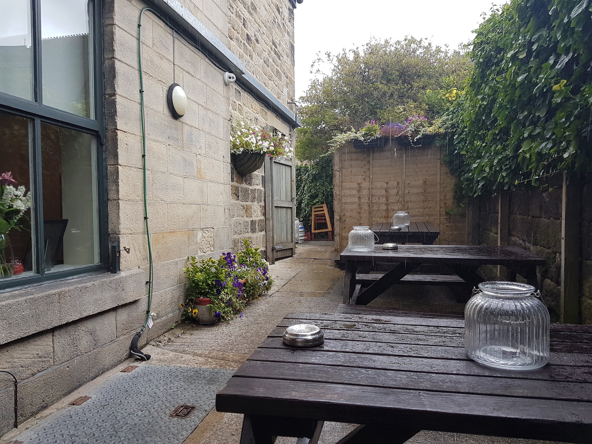 The Tavern's small patio with wooden tables and hanging flowers