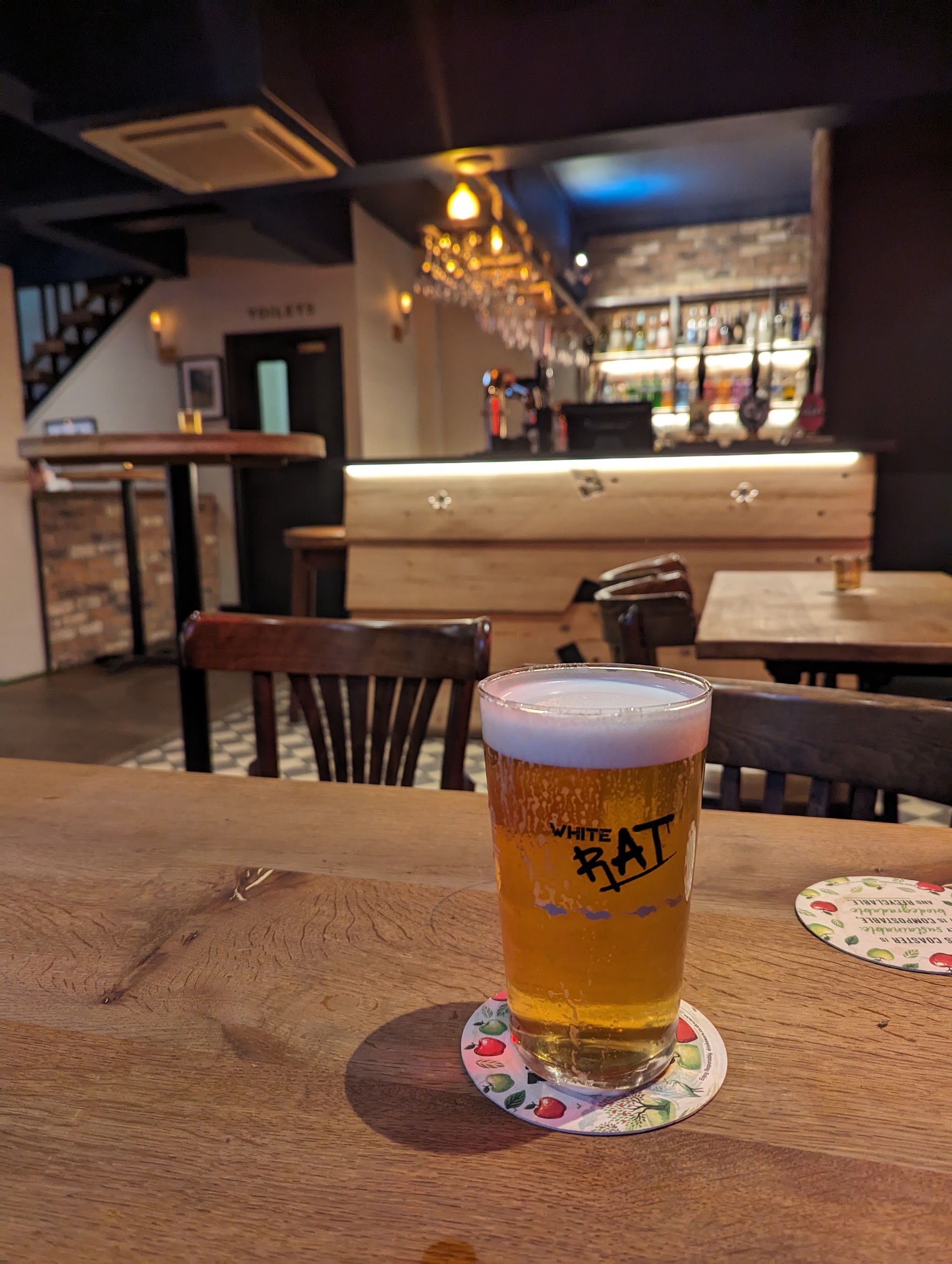 A freshly poured White Rat pint in front of The Tavern's timber bar